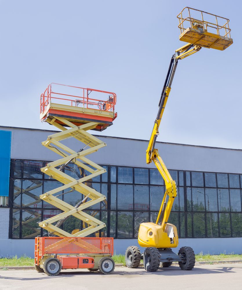 Two scissor lifts are parked in front of a building — MPE Adventure Quads & Bikes In Thornton, NSW