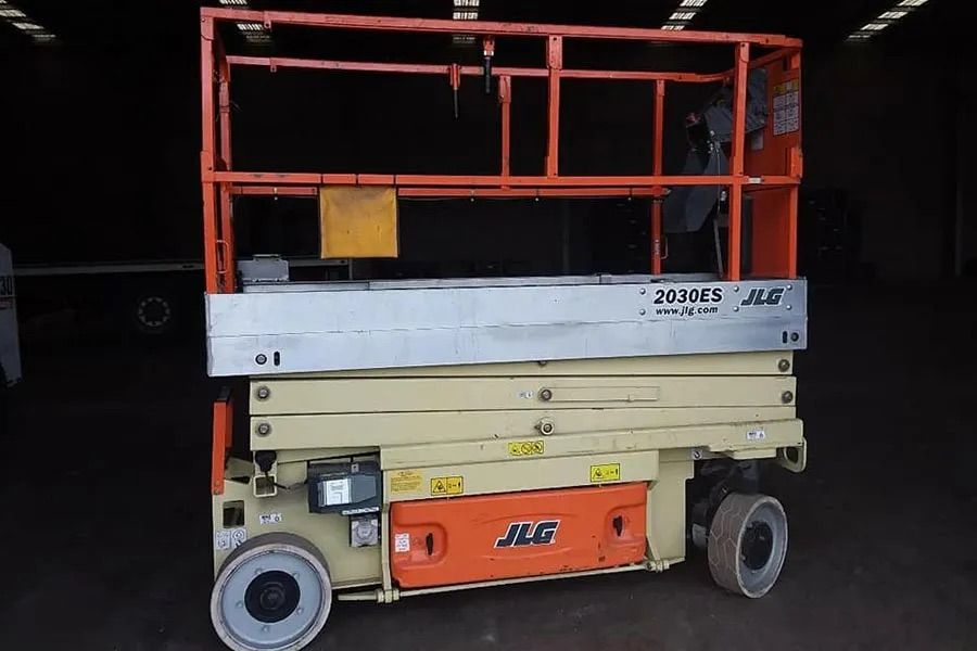 A JLG scissor lift is parked in a garage — MPE Adventure Quads & Bikes In Forster, NSW