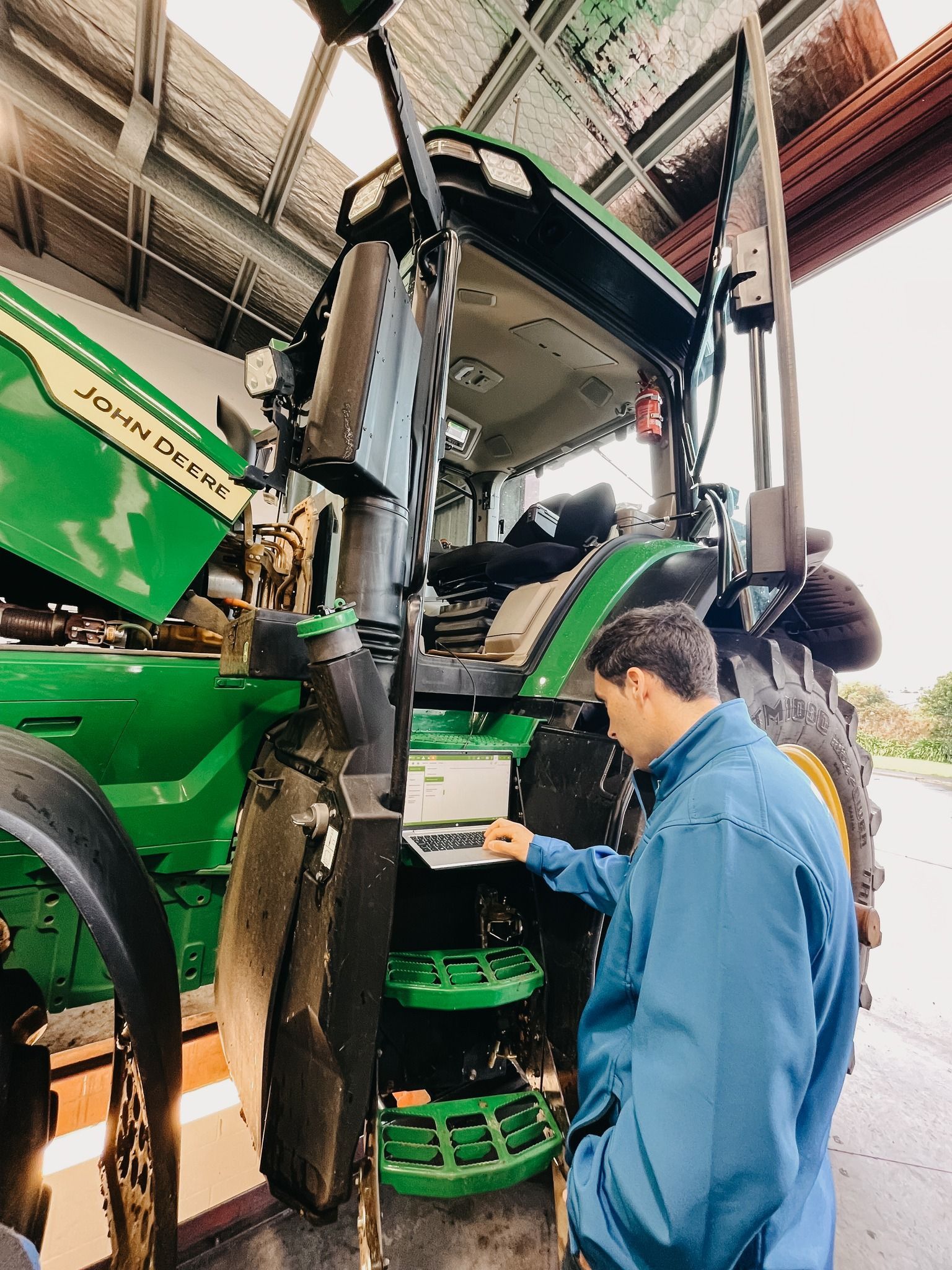 A Man in a Yellow Shirt is Working on a Red Tractor — MPE Adventure Quads & Bikes In Thornton, NSW