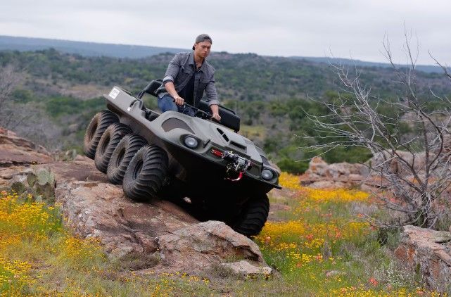 A Man Is Riding a Four Wheeler ATV on A Dirt Road — MPE Adventure Quads & Bikes In Gloucester, NSW