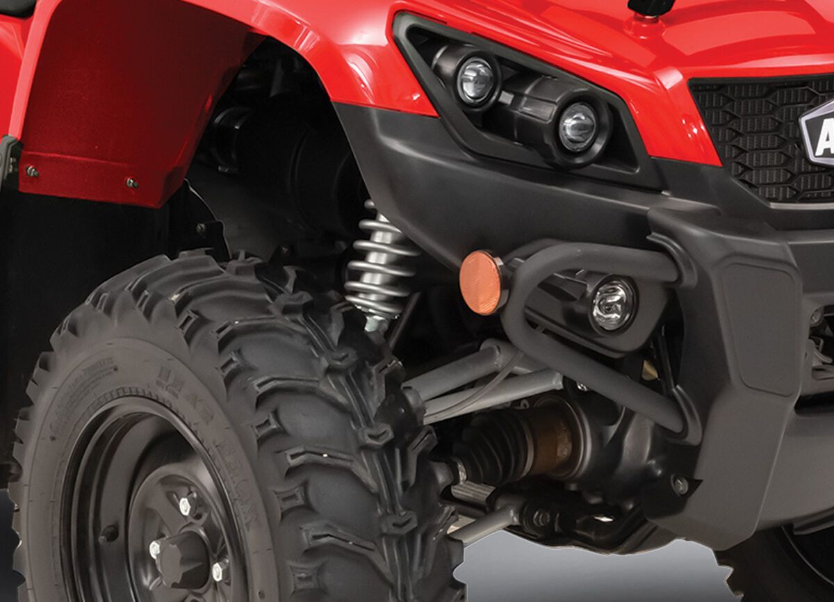 A Red ATV Is Driving Through the Mud on A Dirt Road — MPE Adventure Quads & Bikes In Taree, NSW