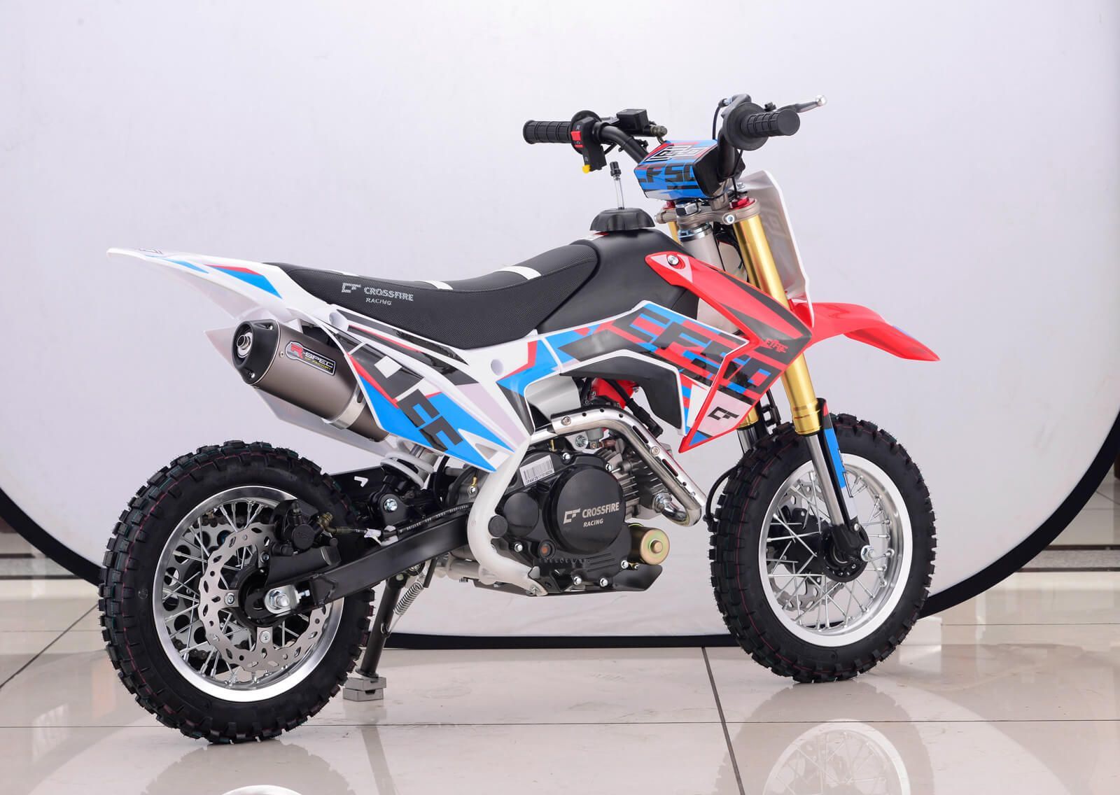 A red , white and blue dirt bike is parked on a tiled floor — MPE Adventure Quads & Bikes In Central Coast, NSW