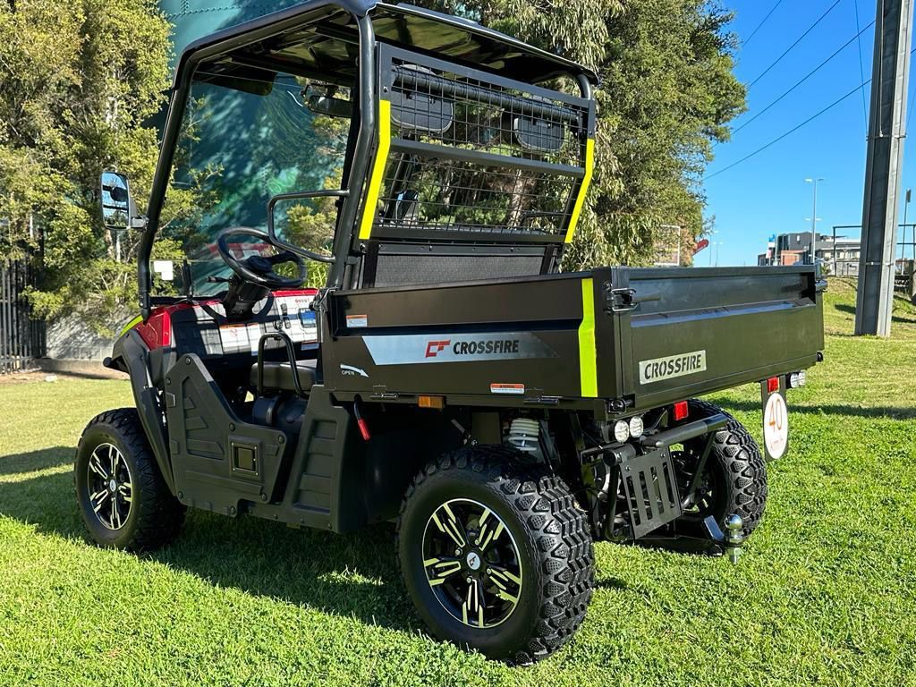 A Black and Red Utility Vehicle is Parked in a Grassy Field — MPE Adventure Quads & Bikes In Port Stephens, NSW