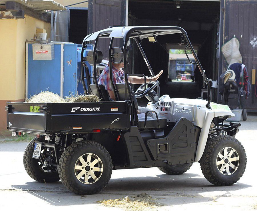 A man is driving a utility vehicle with hay in the back — MPE Adventure Quads & Bikes In Central Coast, NSW