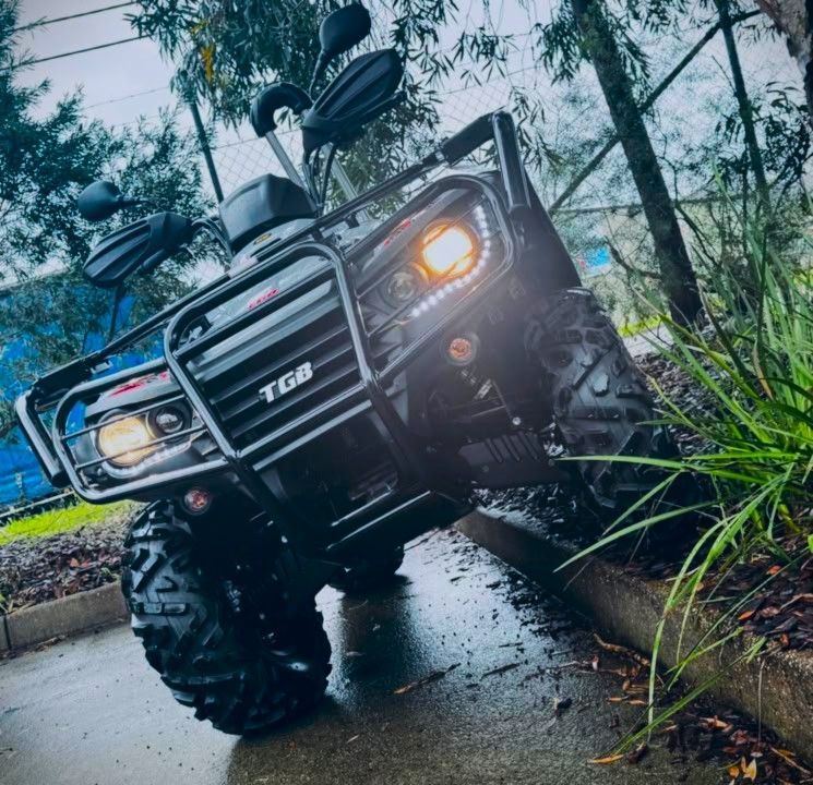 Black ATV Parked on Wet Pavement, Surrounded by Green Trees — MPE Adventure Quads & Bikes In Thornton, NSW