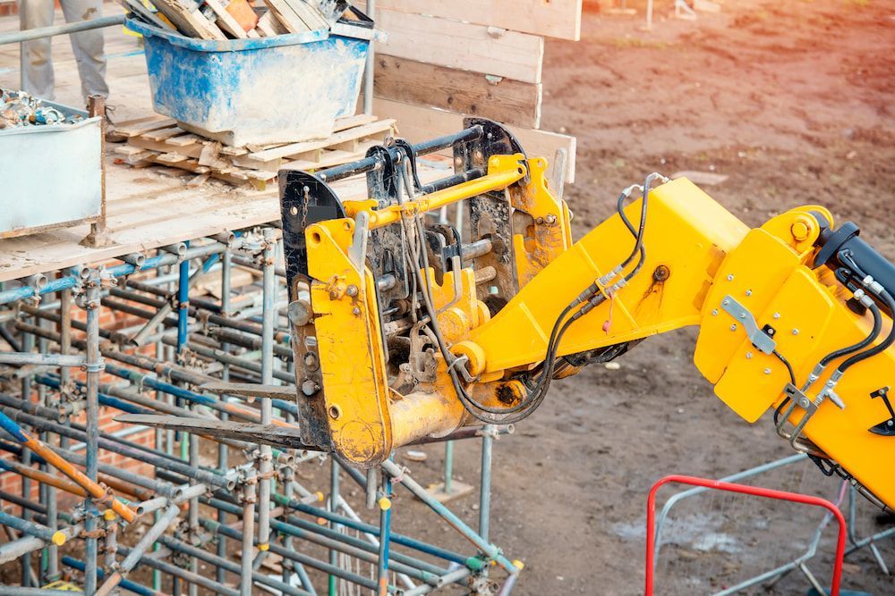 A Yellow Robotic Arm is Working on a Construction Site — MPE Adventure Quads & Bikes In Pokolbin, NSW