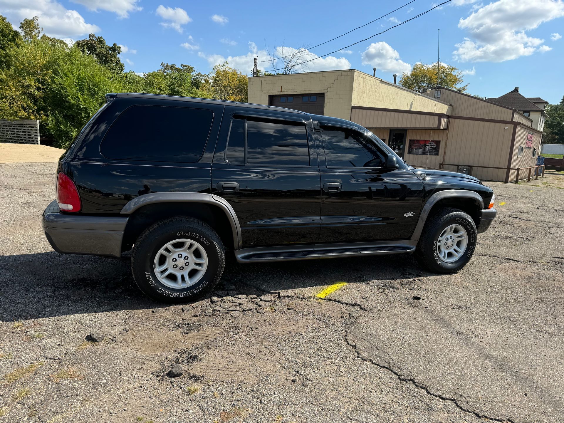 A black suv is parked in a parking lot in front of a building.