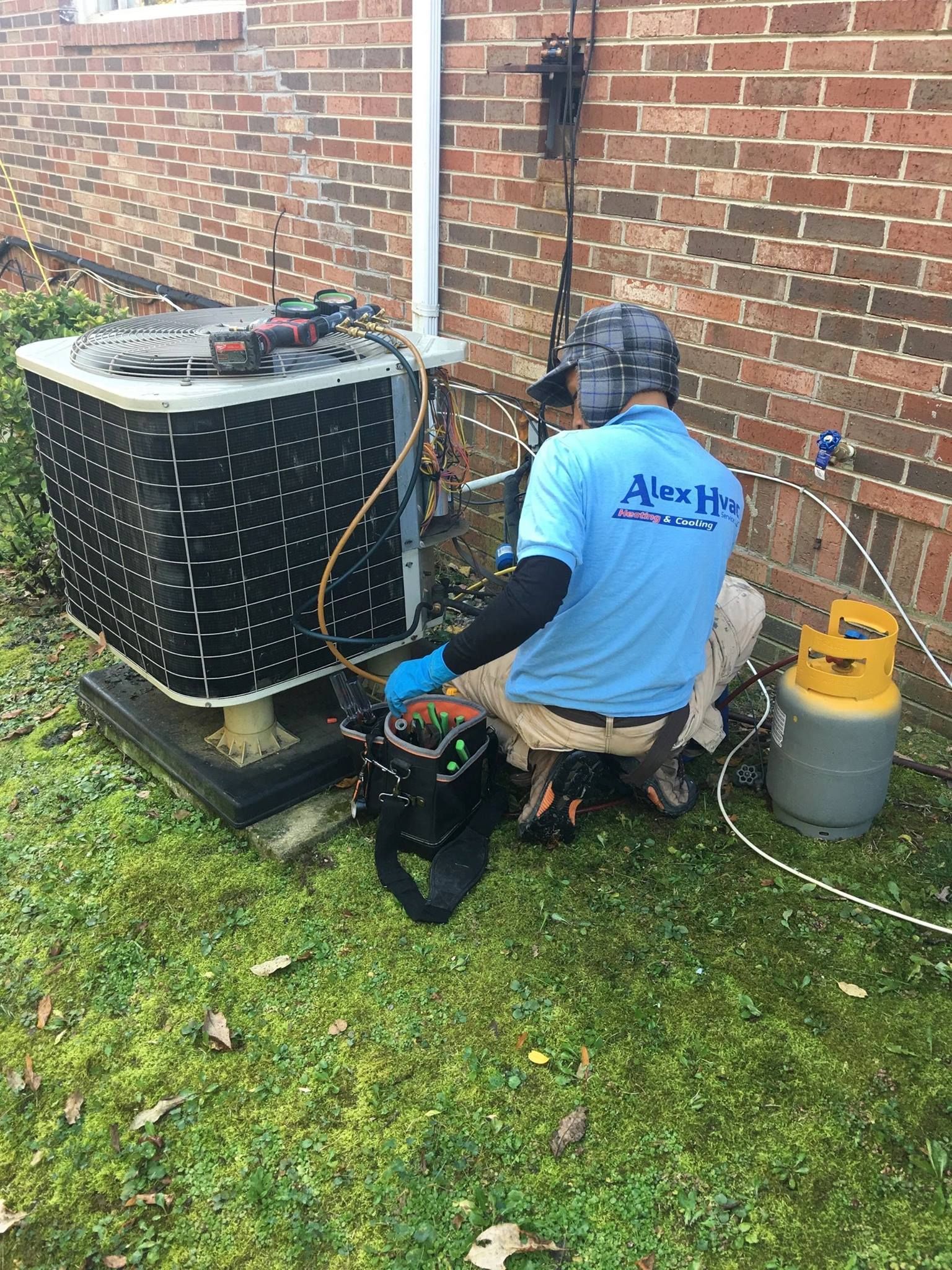 Alex HVAC Service LLC technician repairing residential air conditioner with full tool setup