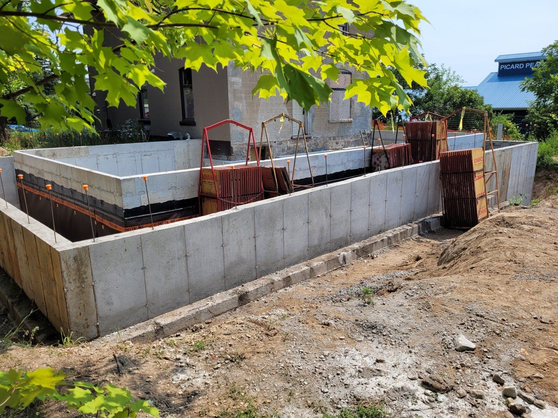 A concrete wall is being built in front of a house.