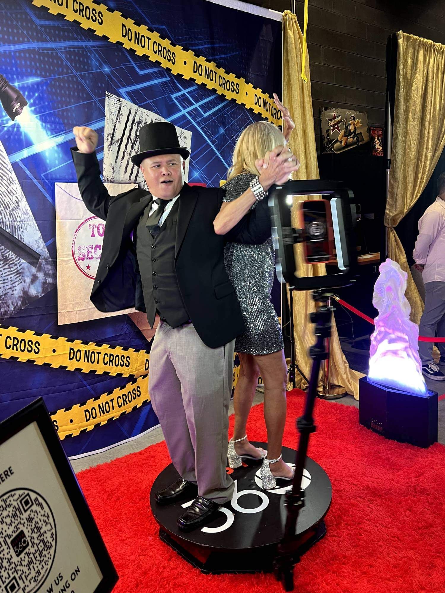 Guest posing with microphone at Fiesta 360 gold sequin backdrop photo booth