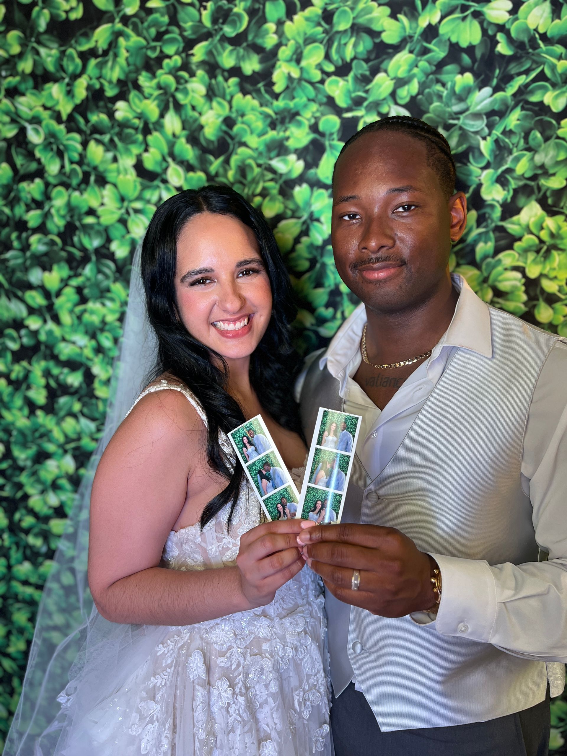 Couple smiling at Fiesta 360 wedding photo booth greenery backdrop Tampa