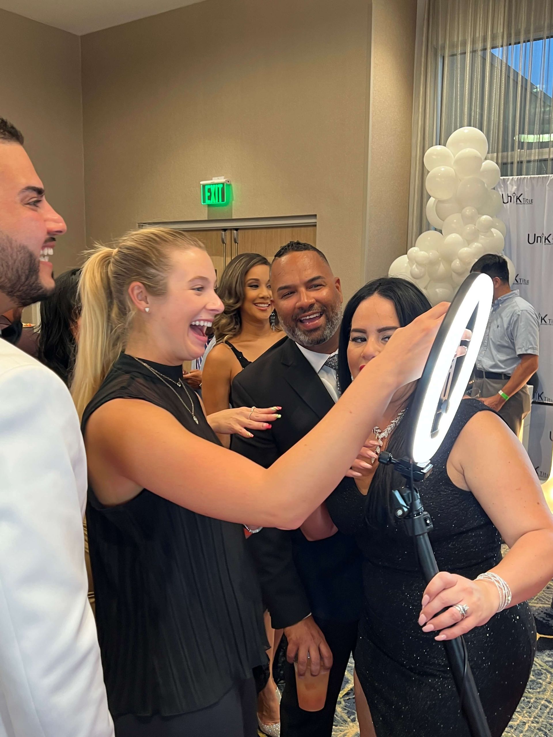 A group of people are posing for a picture with a ring light.