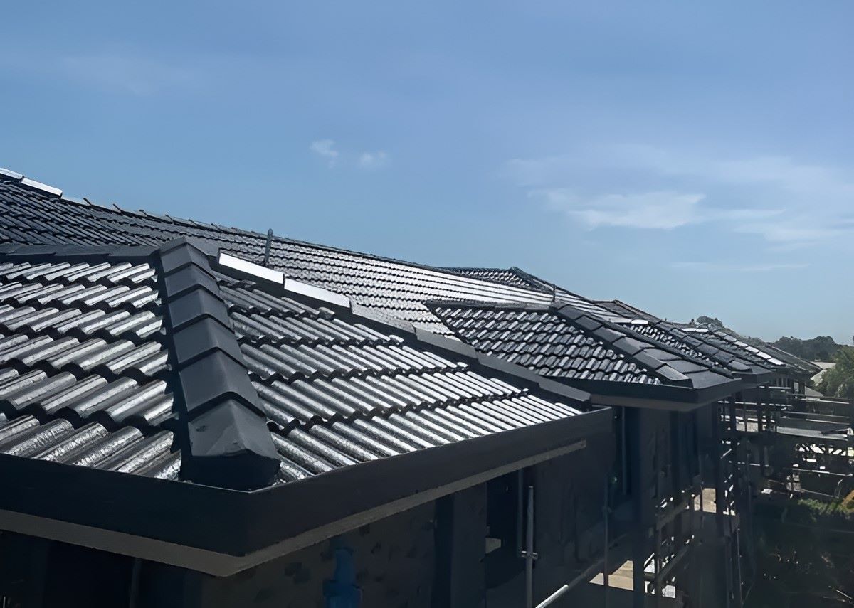 A Roof Of A House Under Construction With A Black Tiled Roof — Lance Ward Roof Tiling in Parkes, NSW