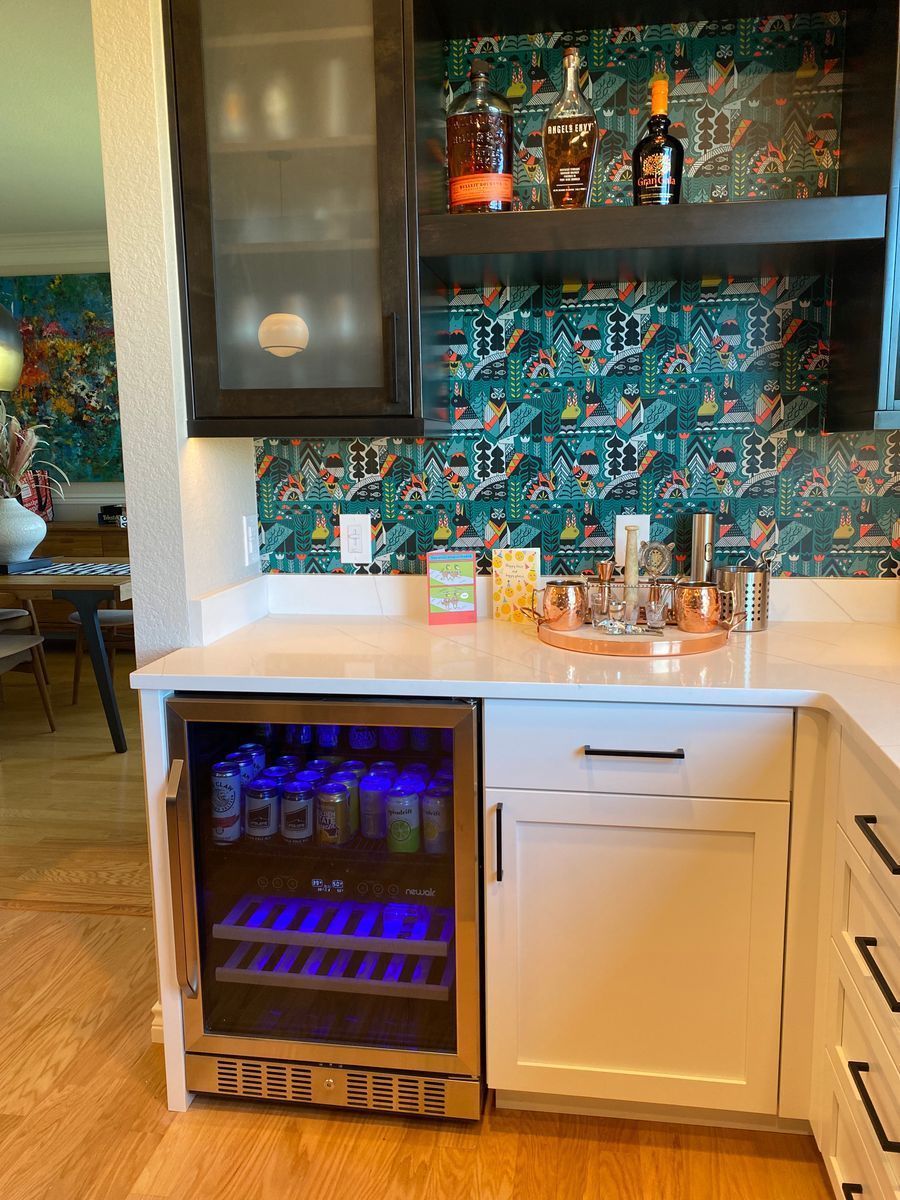 A kitchen with a wine cooler and a sink.