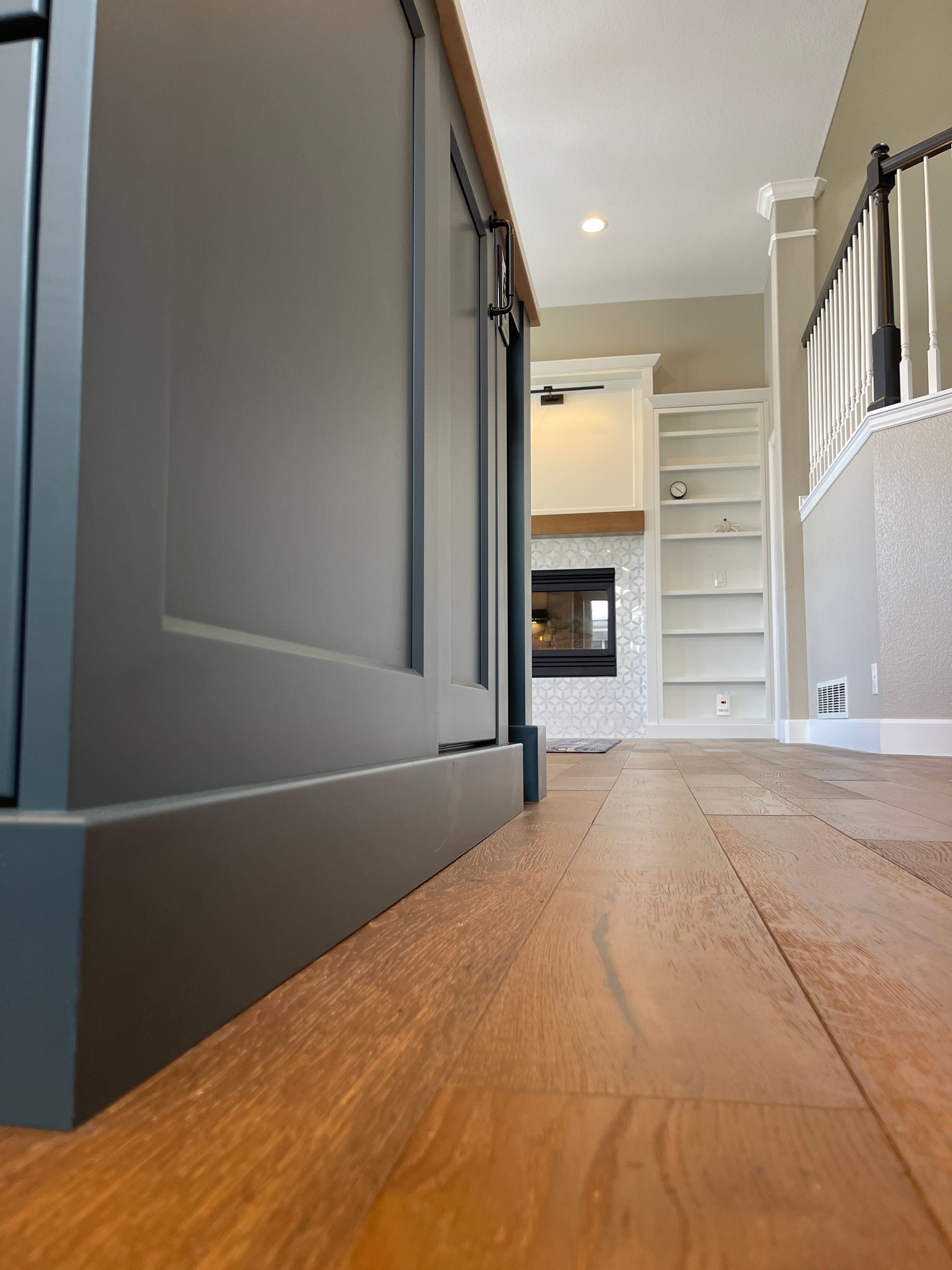 A kitchen with hardwood floors and gray cabinets