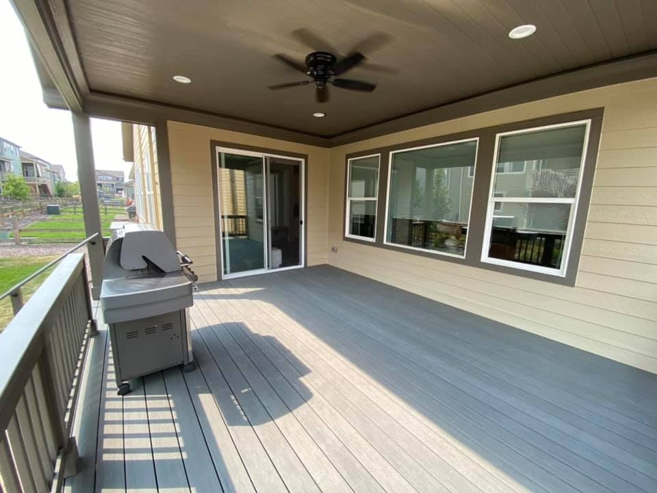 A large deck with a grill and a ceiling fan.
