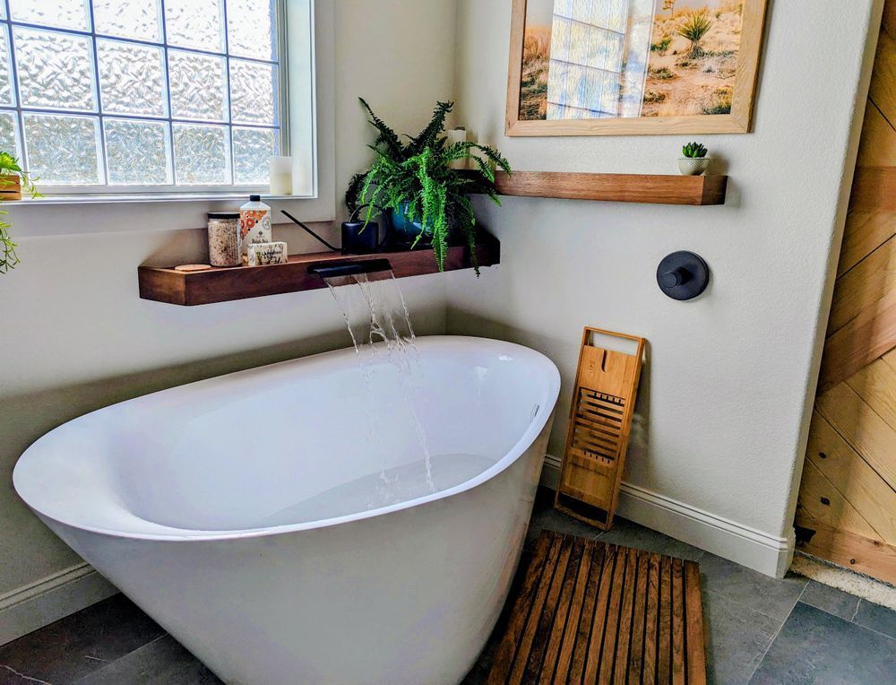 A bathtub is sitting in a bathroom next to a window.
