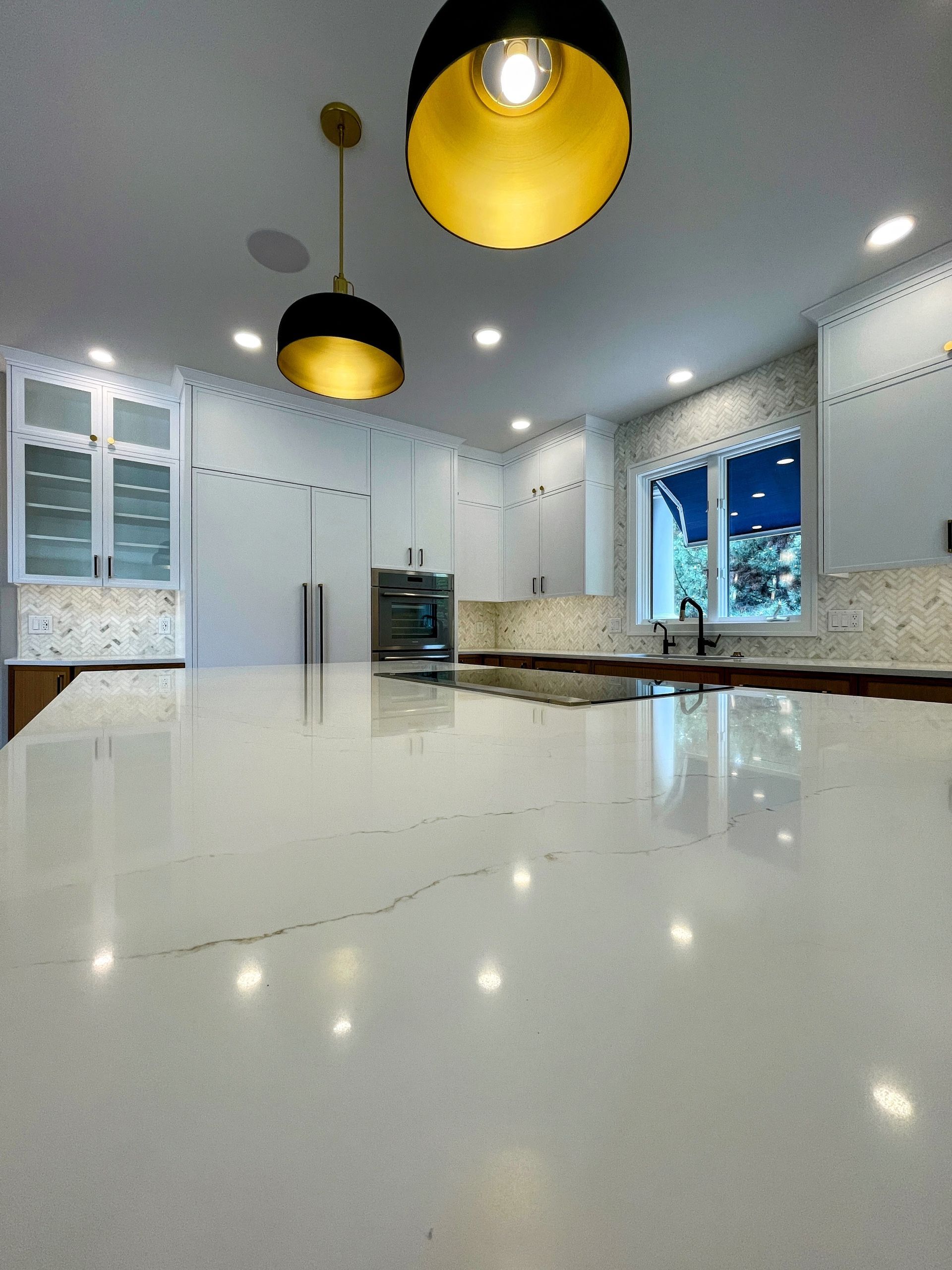 A kitchen with white cabinets and a large counter top