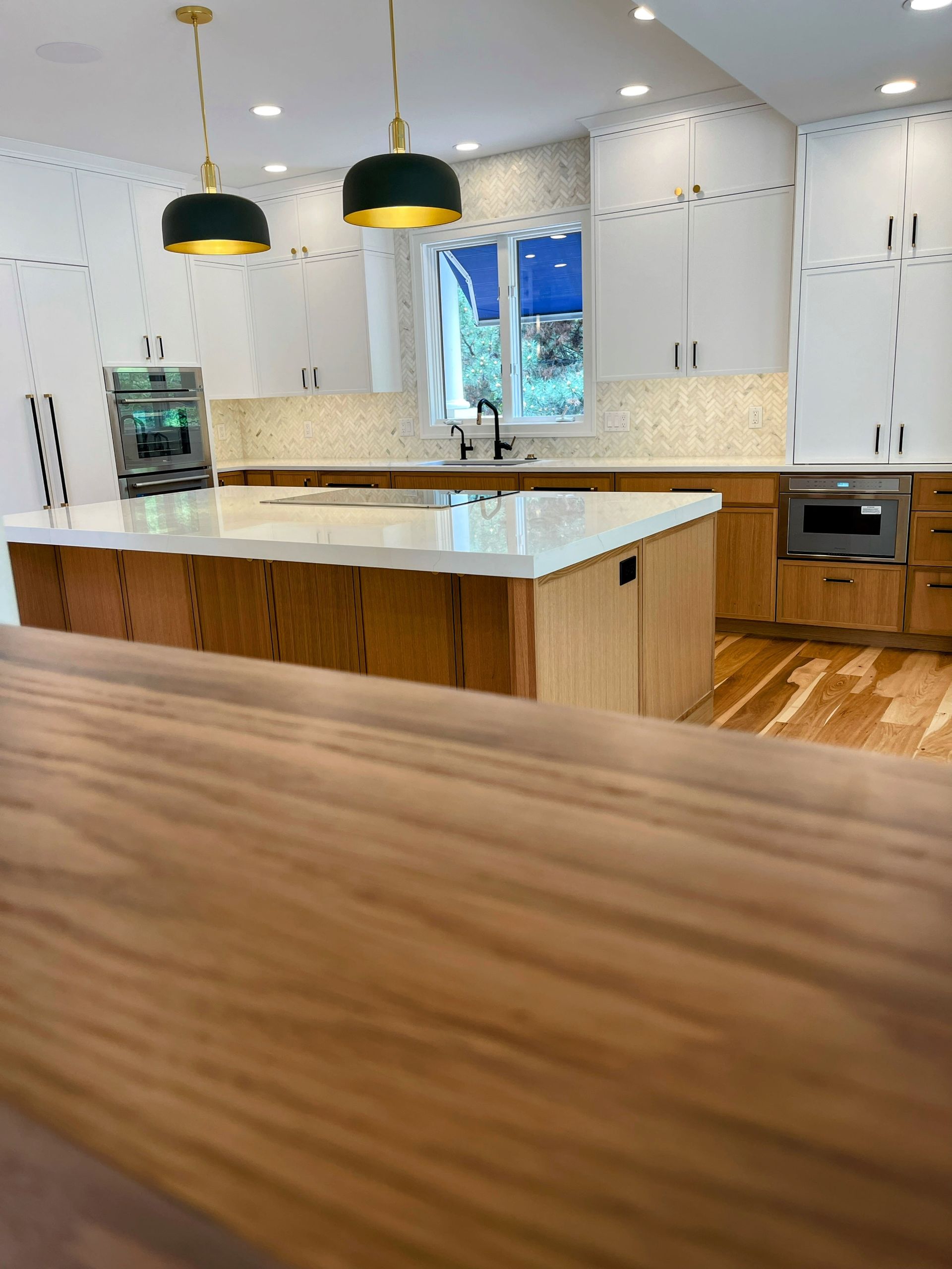 A kitchen with white cabinets and wooden counter tops