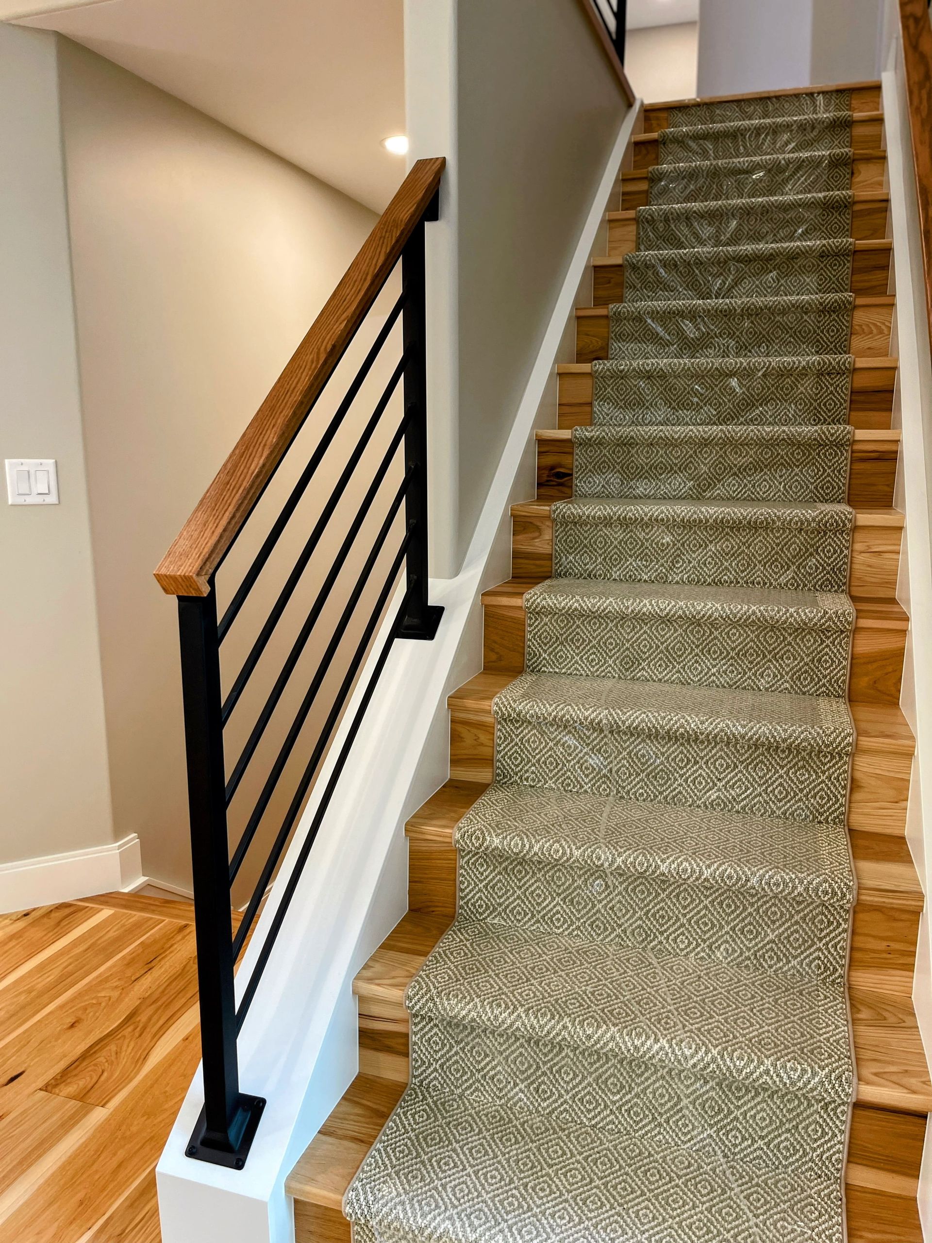 A staircase with a carpeted staircase and a wooden railing.