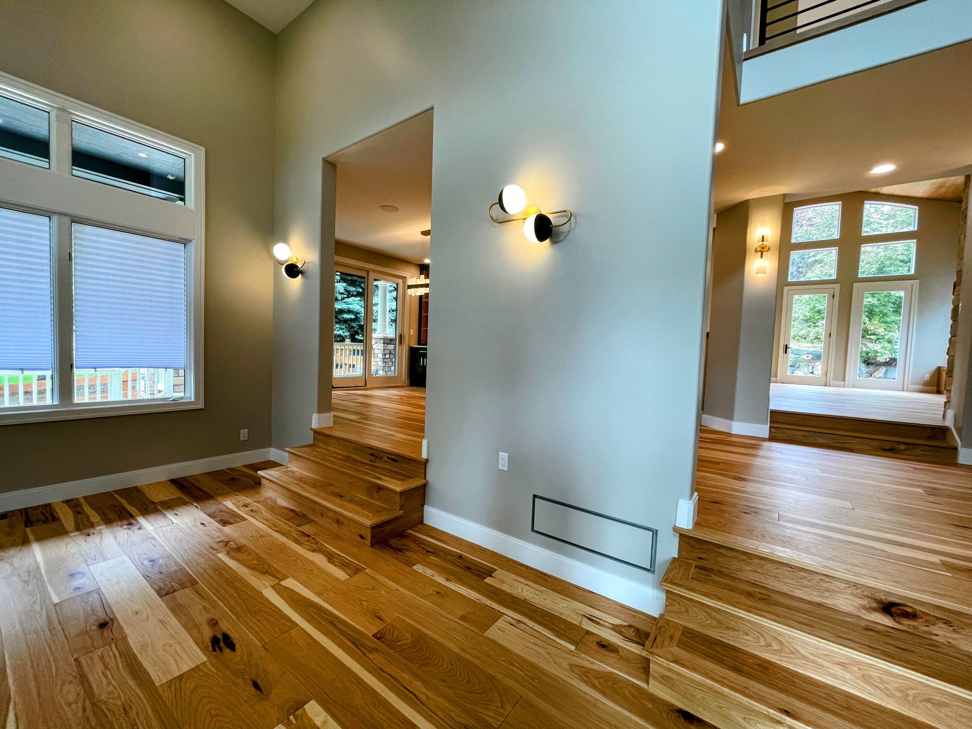 A living room with hardwood floors and stairs in a house.