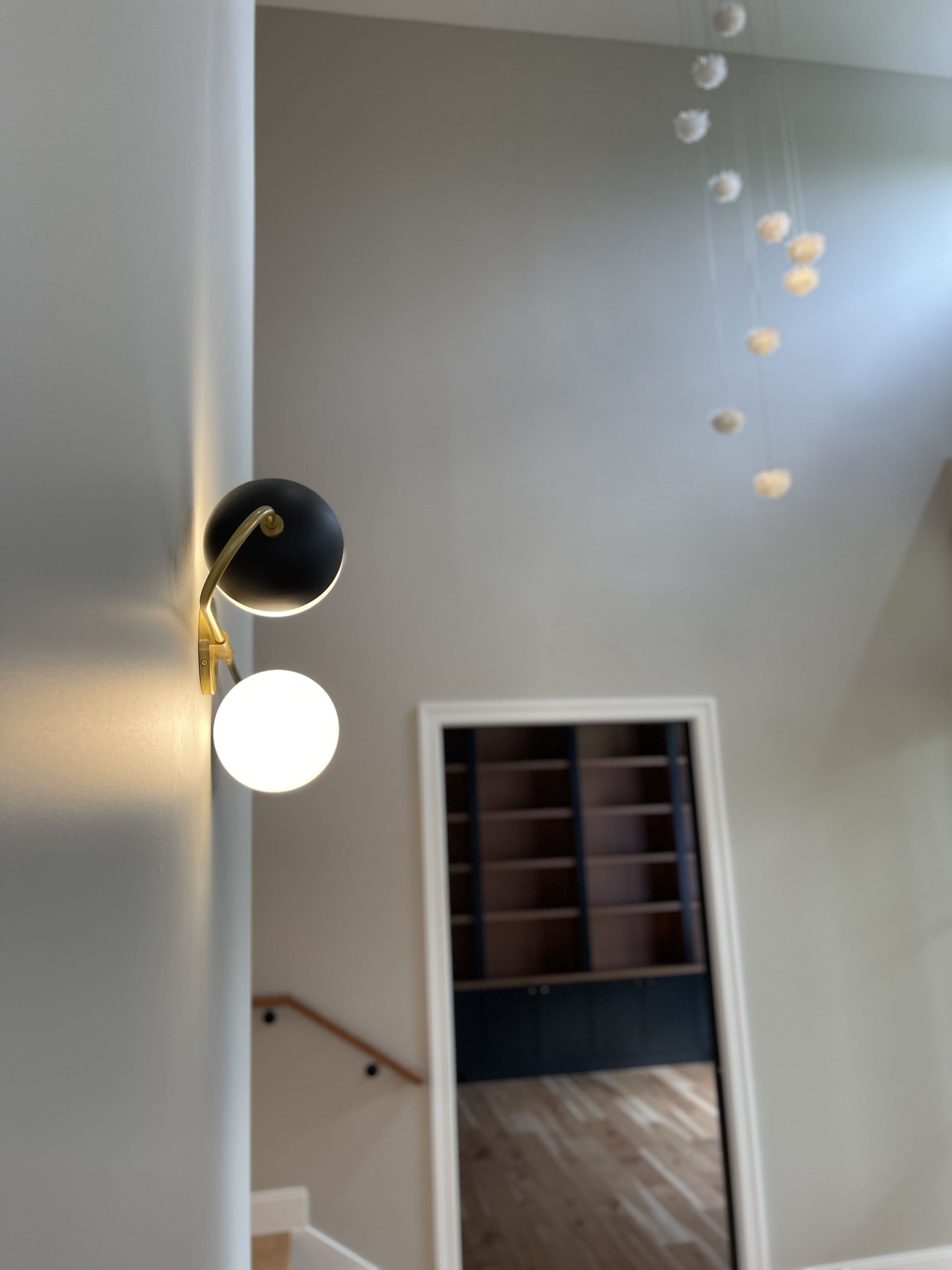 A staircase with a mirror and a light on the wall