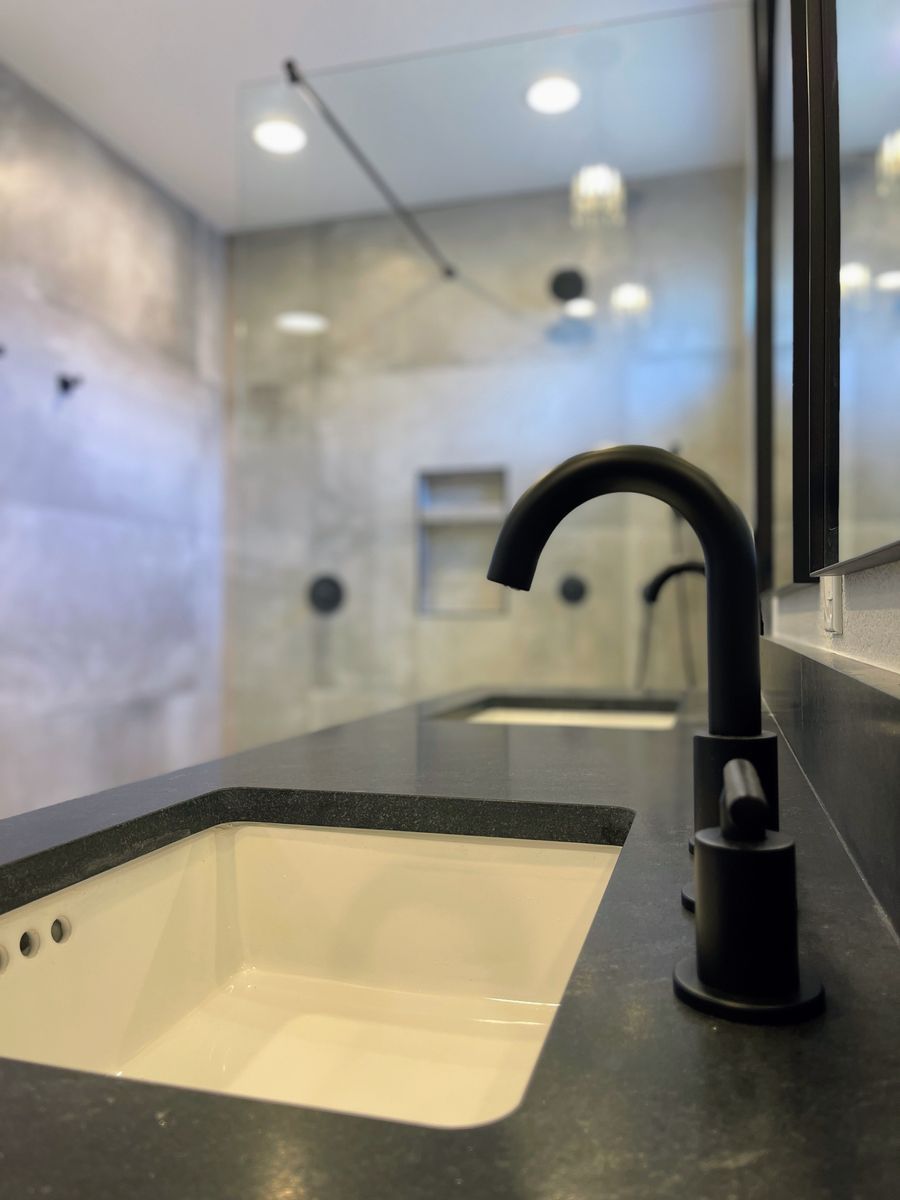 A bathroom with two sinks and a black faucet