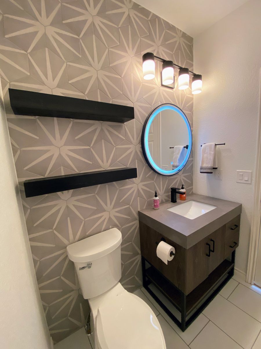 A bathroom with a toilet , sink and mirror
