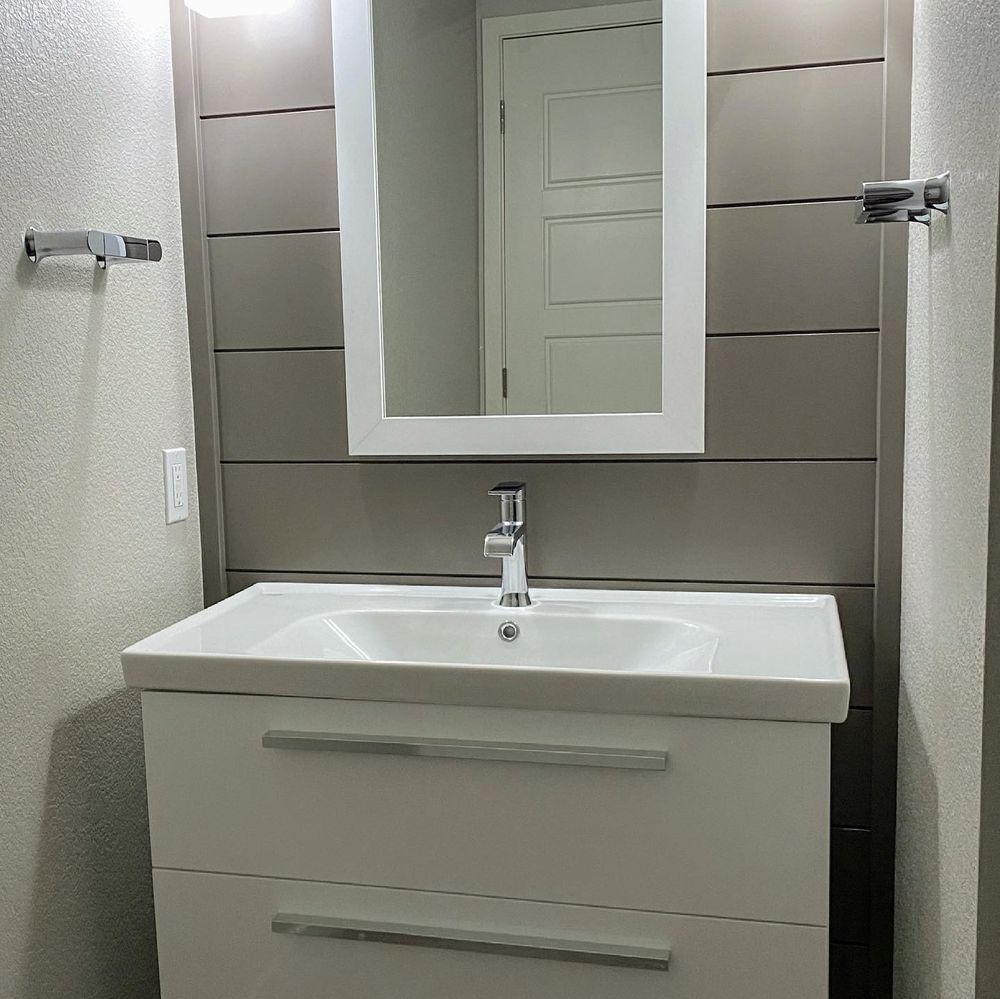 A bathroom with a sink and a mirror above it