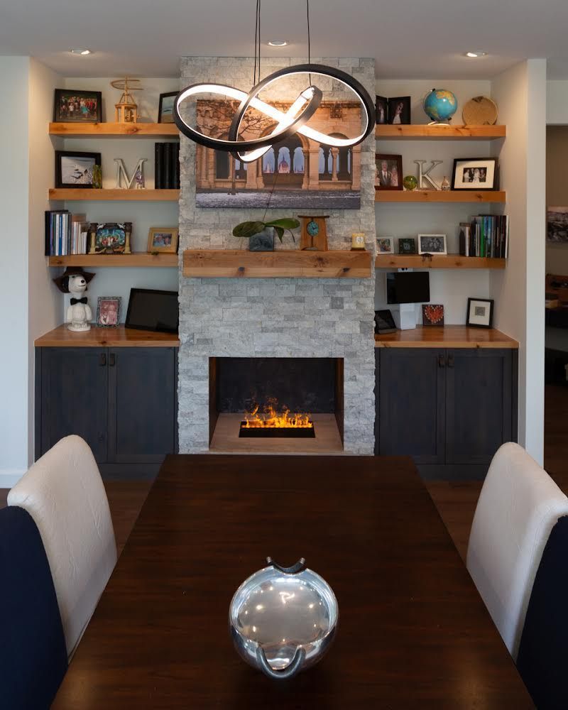 A dining room with a table and chairs and a fireplace
