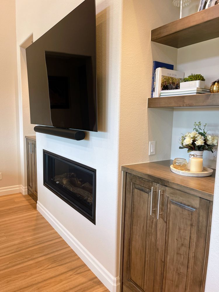 A living room with a fireplace and a flat screen tv mounted on the wall.