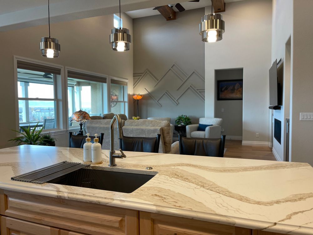 A kitchen with a sink and a marble counter top.