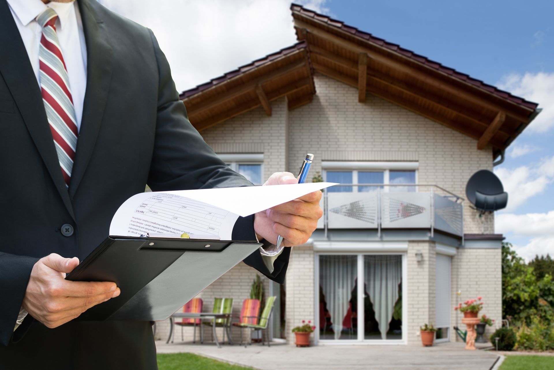 Real estate agent holding clipboard in front of a suburban house