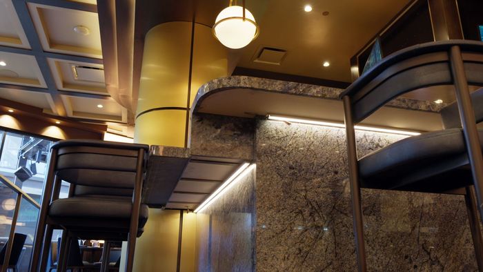 Modern hotel lobby with curved balconies, warm lighting, and textured stone walls