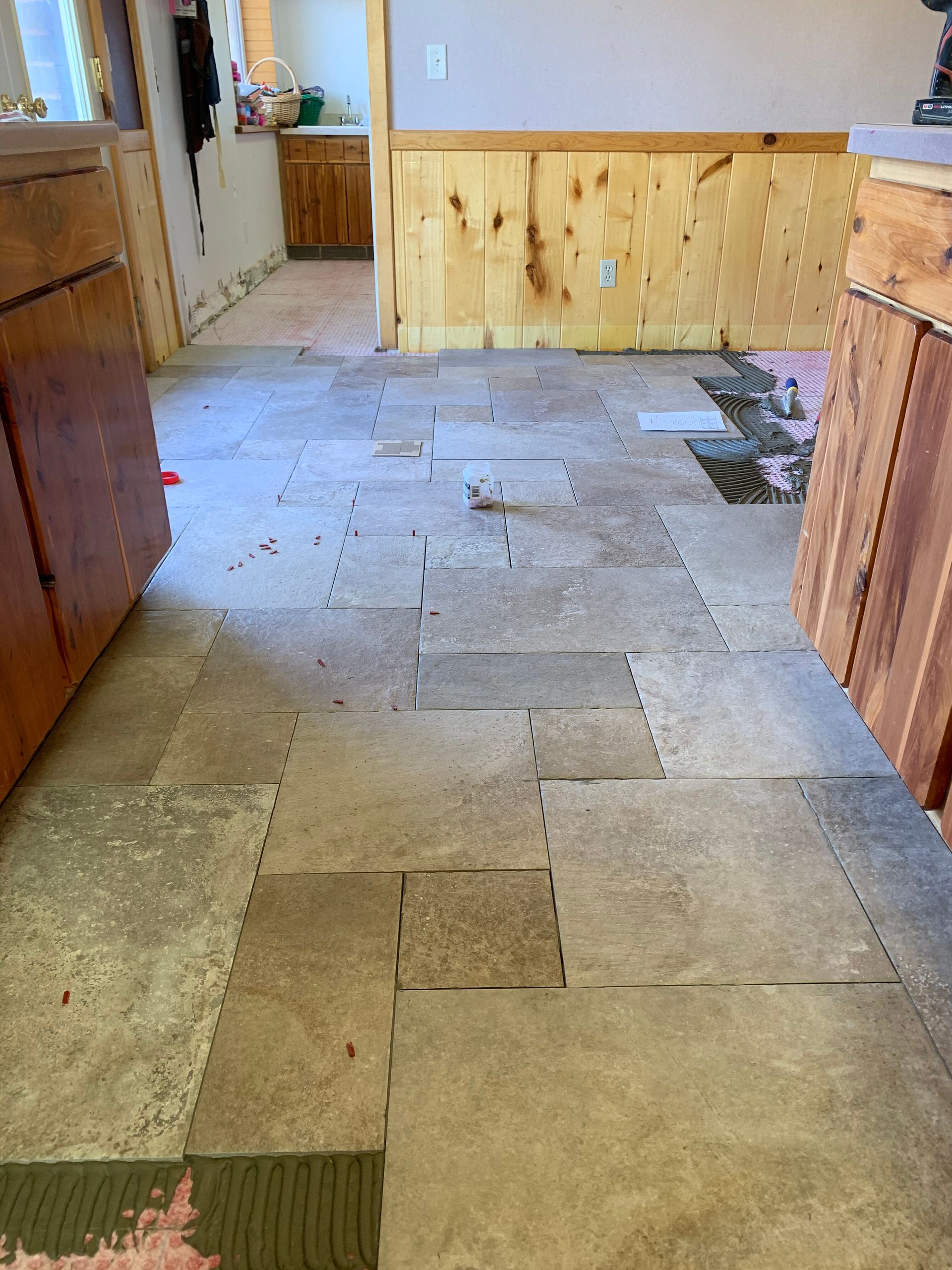 Renovation with exposed subfloor and debris leading to a wooden counter in a room under construction