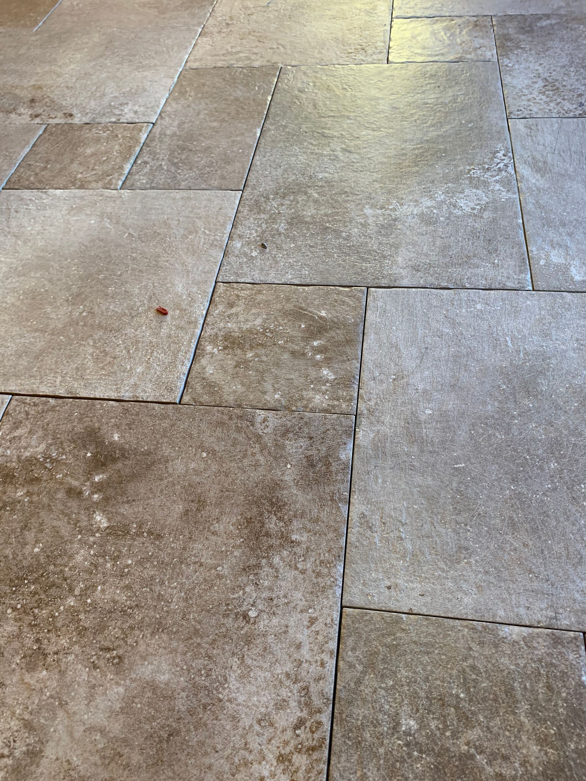 Weathered stone pavement with large square tiles in beige and gray tones