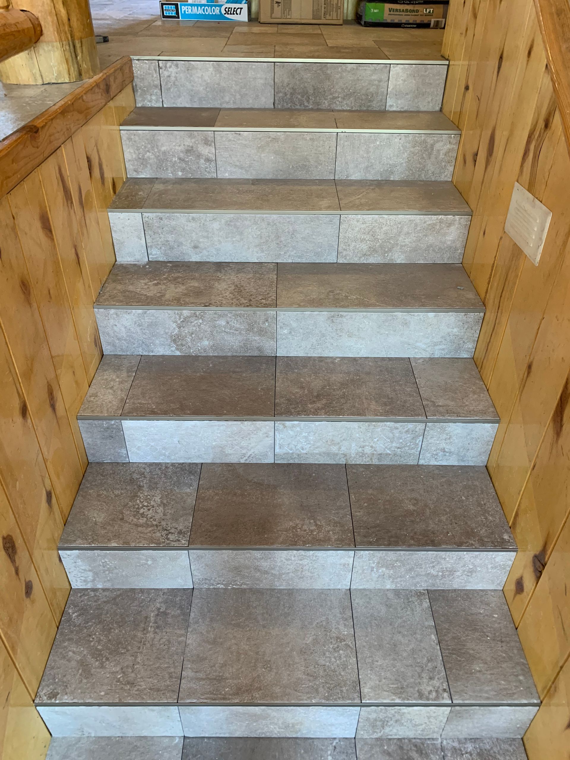 Unfinished staircase under construction with wooden side framing and gray steps covered in protective material