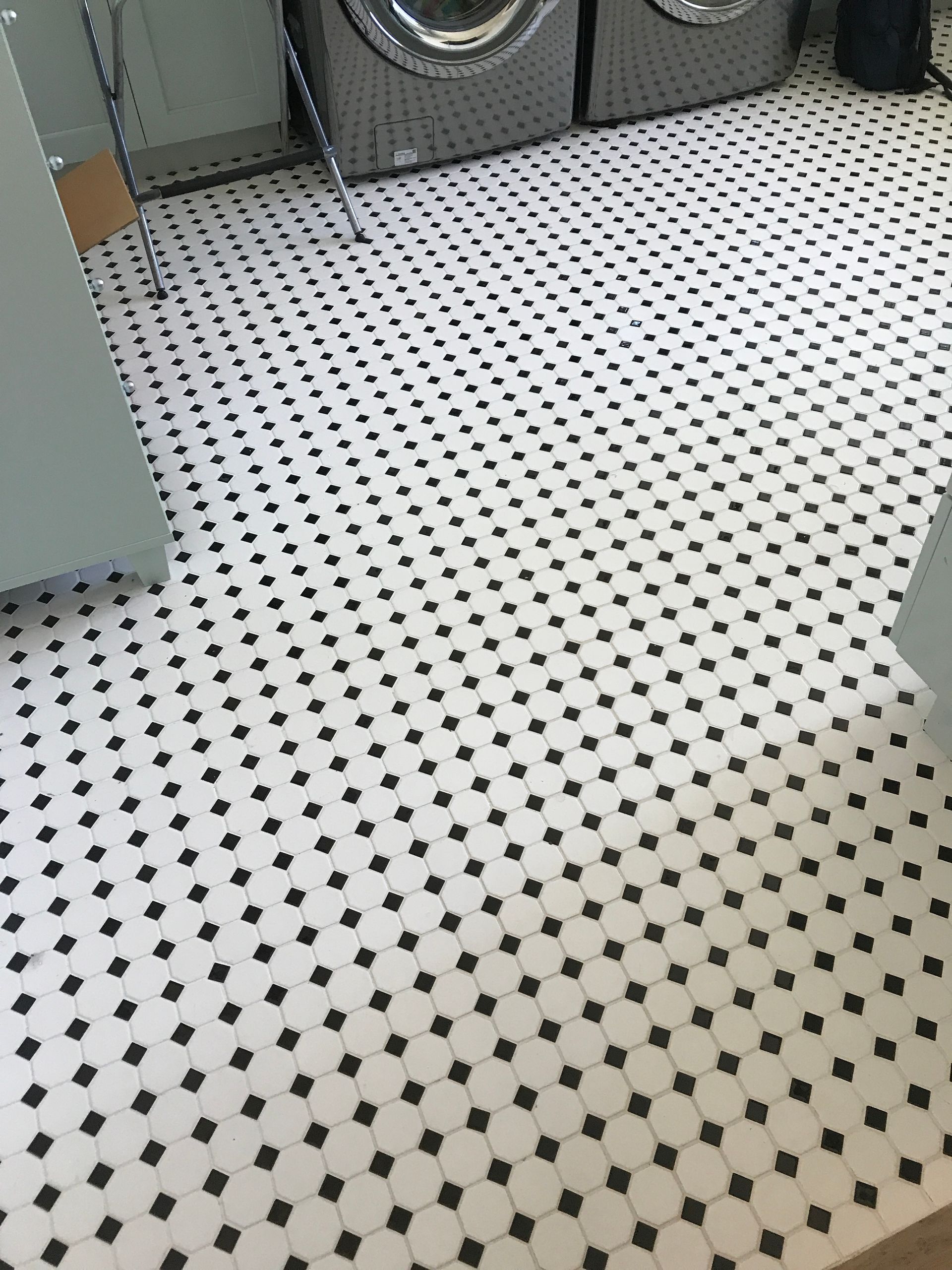 Black-and-white patterned kitchen floor with appliances along the walls