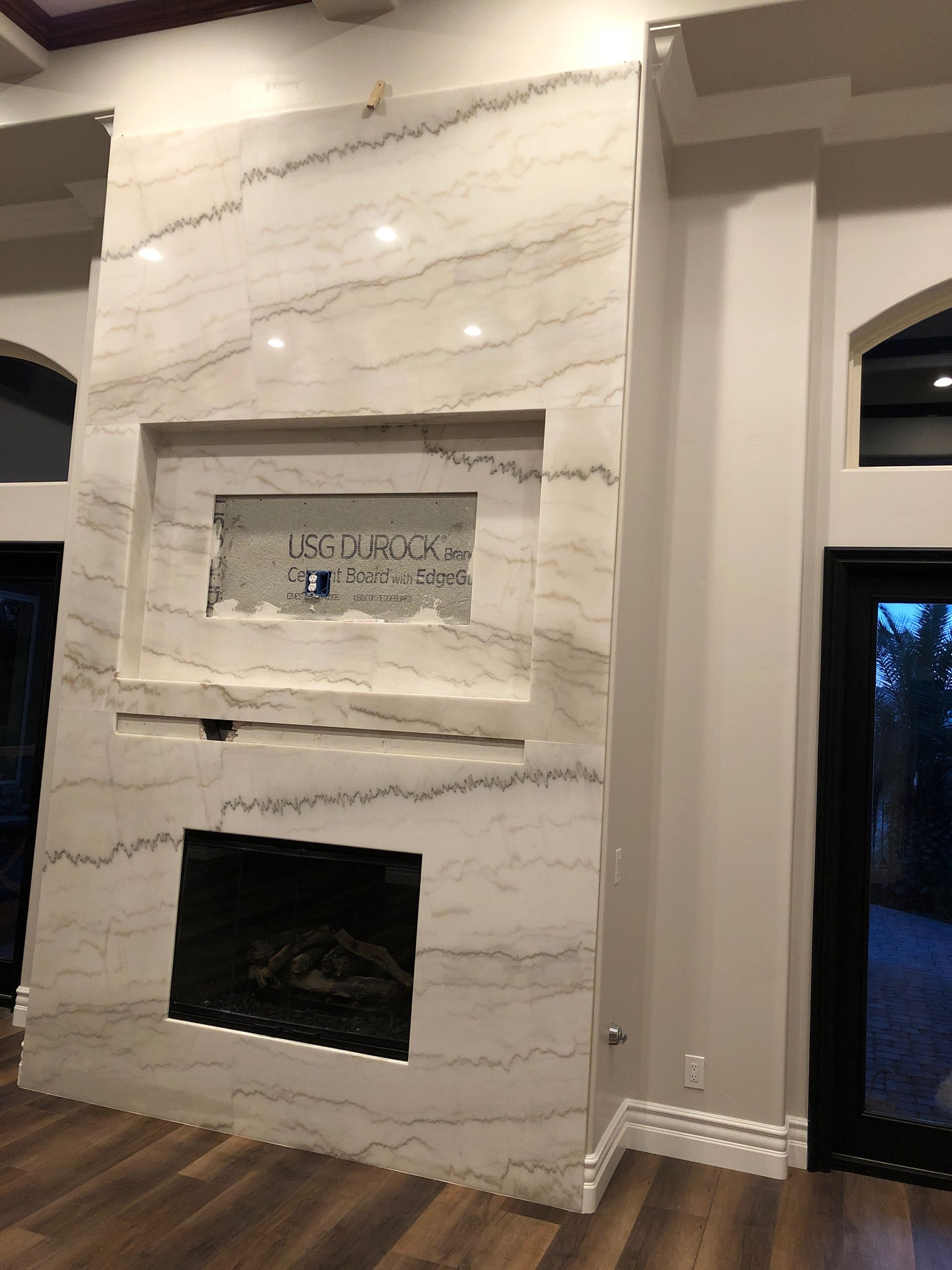 White textured fireplace wall with two recessed openings in a modern room