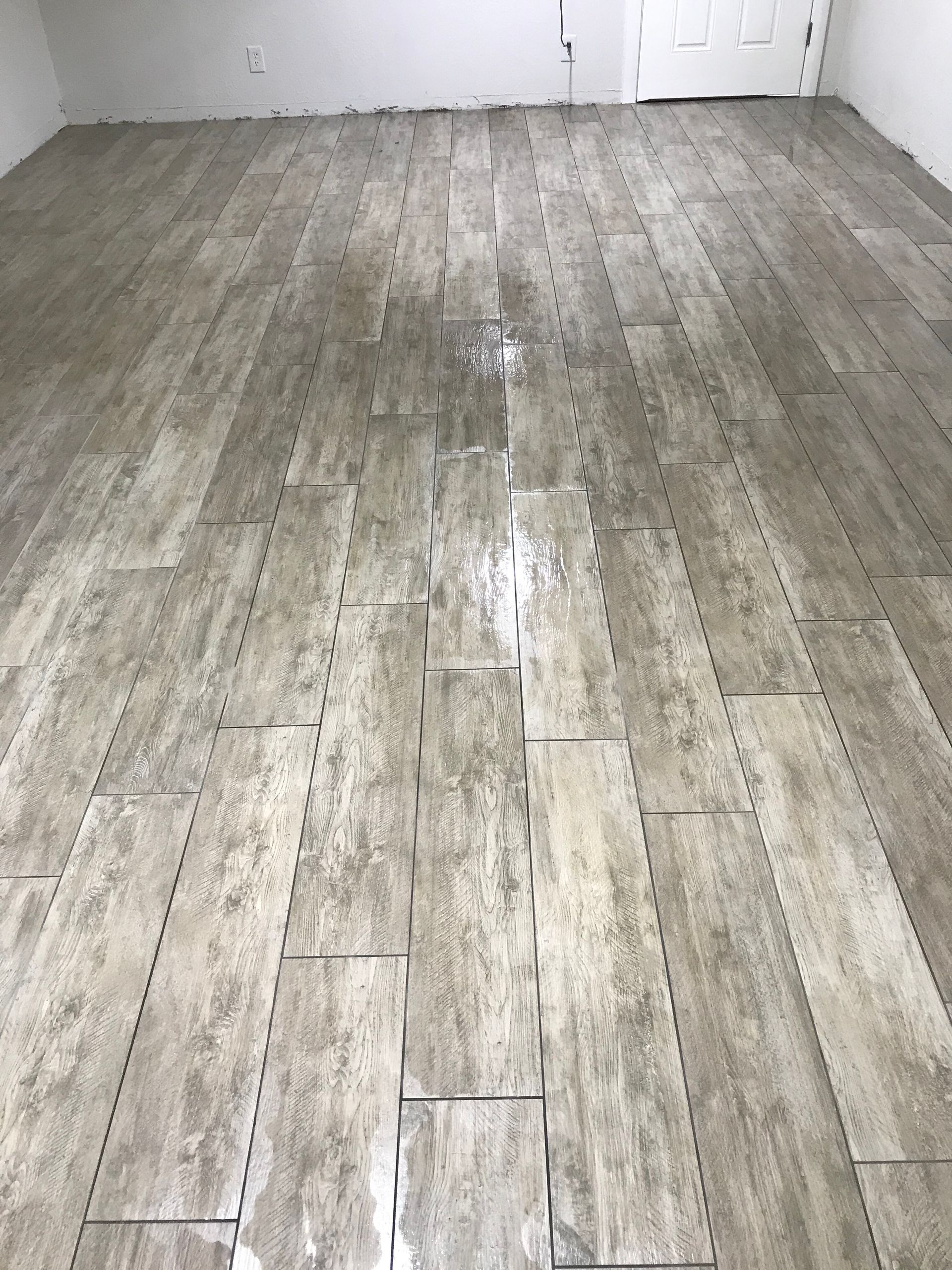 Empty room with gray wood-look plank flooring and white walls