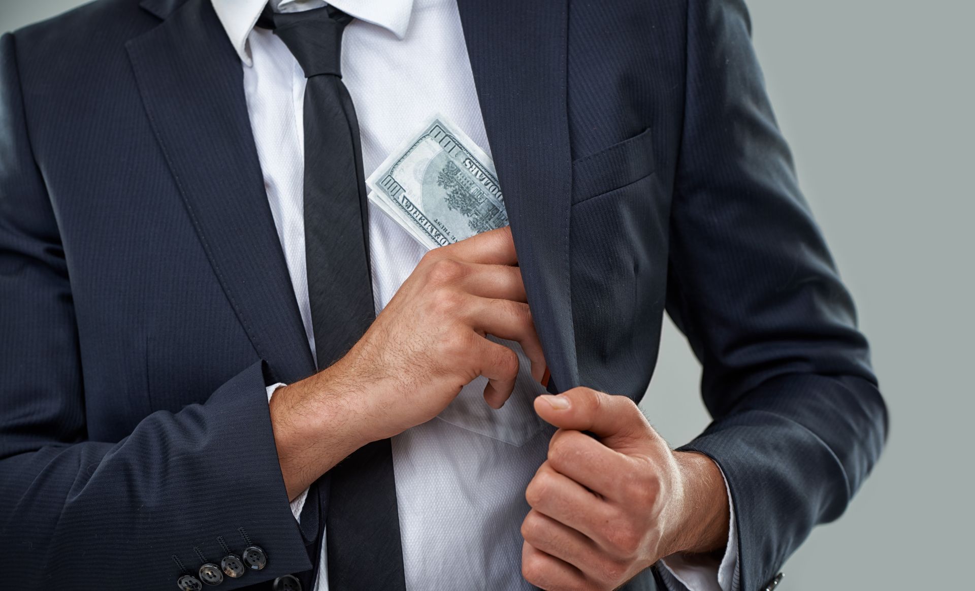 business man putting money on his jacket pocket