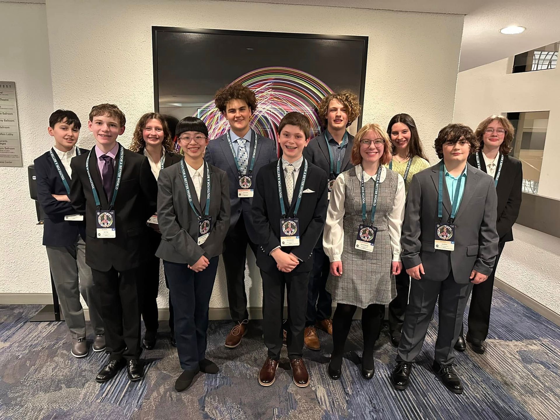 A group of montessori students in suits and ties are posing for a picture.