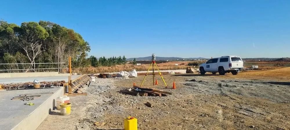 Construction Site With Concrete Foundation, Orange Cones, and a White Truck — Coastal Surveying Group Pty Ltd In Baringa, QLD