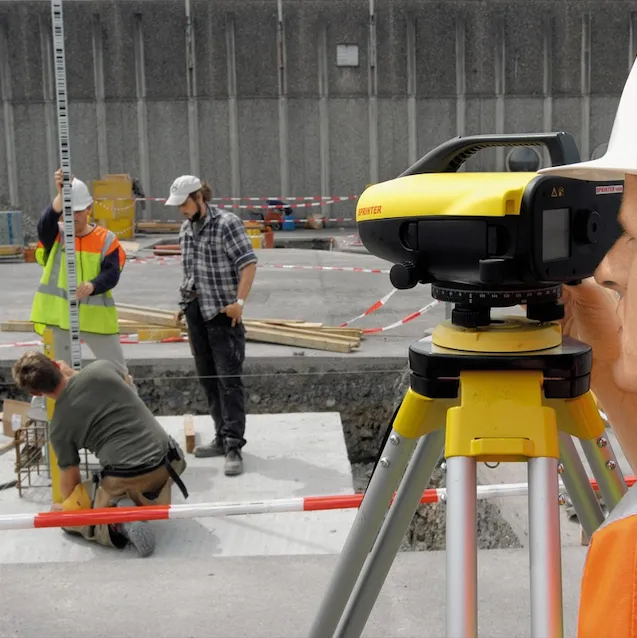 Construction Workers Using Surveying Equipment on a Road Site — Coastal Surveying Group Pty Ltd In Baringa, QLD