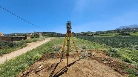 Survey Tripod on a Dirt Hill Overlooking Green Fields and a Winding — Coastal Surveying Group Pty Ltd In Baringa, QLD