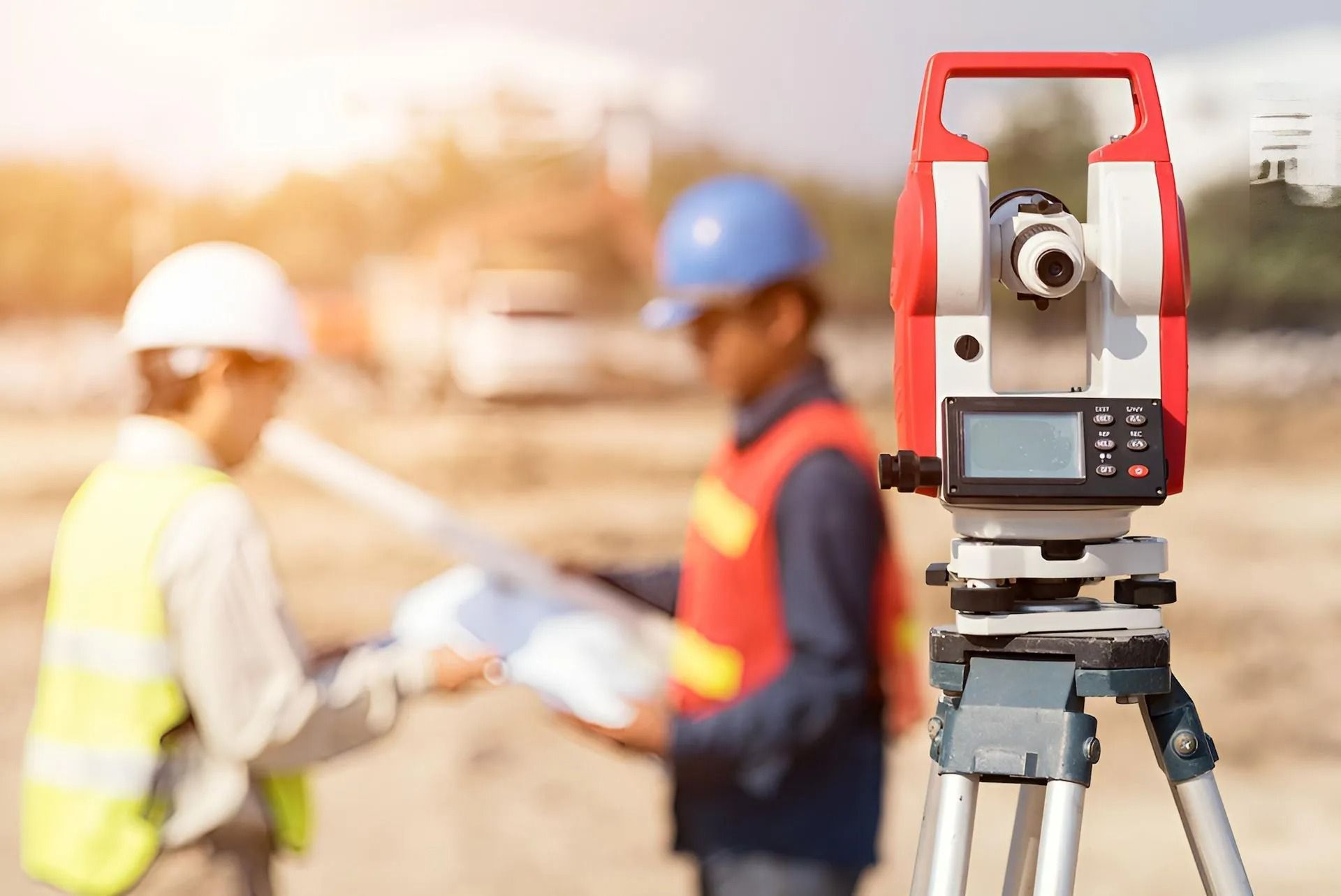 Surveying Equipment on Tripod at Construction Site With Two Workers — Coastal Surveying Group Pty Ltd In Baringa, QLD