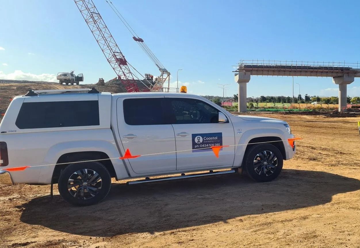 White SUV With Crane Decals Parked at a Construction Site — Coastal Surveying Group Pty Ltd In Sunshine Coast, QLD