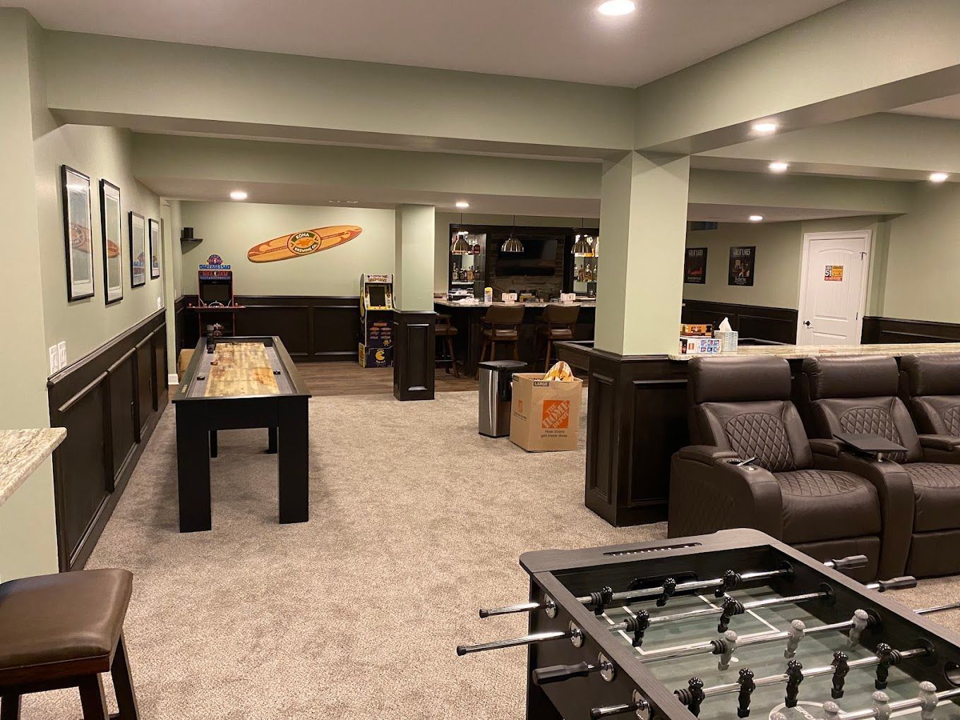 Basement game room with foosball table, pool table, and leather sectional seating