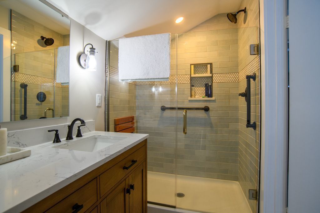 Modern bathroom with double vanity, glass shower, and beige tile walls
