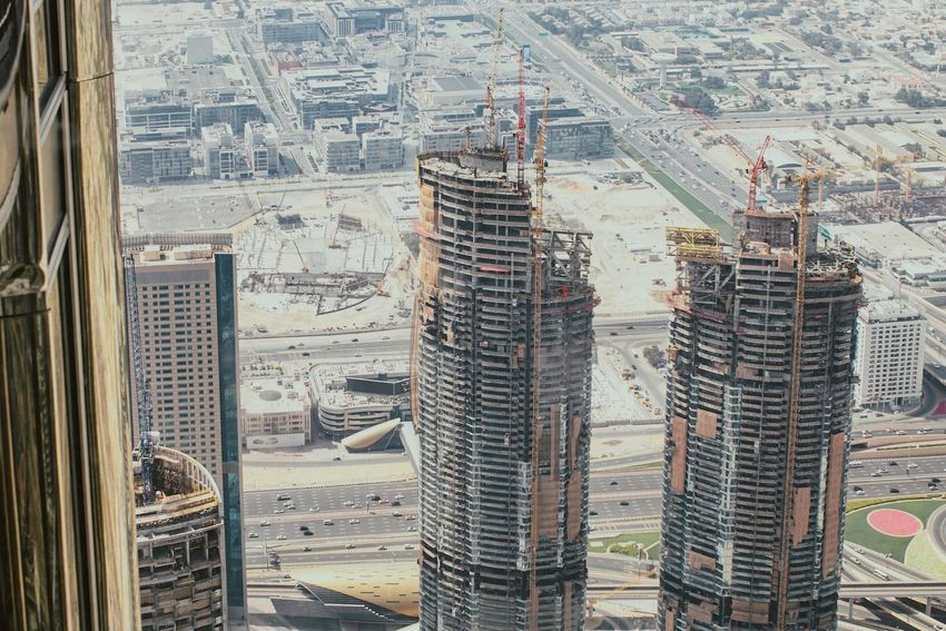 High-rise towers under construction amid a snowy cityscape, viewed from above